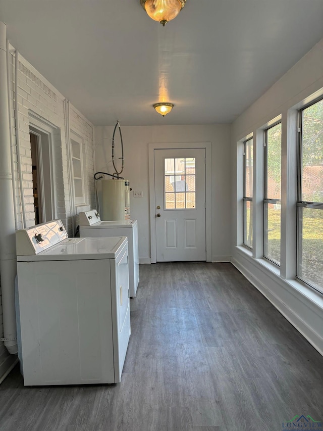 laundry area featuring dark hardwood / wood-style flooring, washer and dryer, and gas water heater