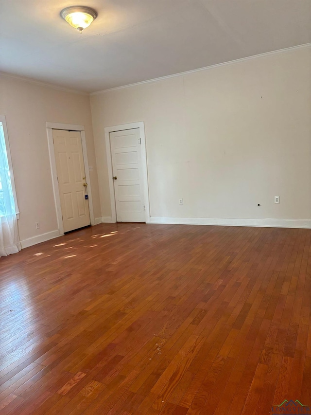 spare room with hardwood / wood-style flooring and crown molding