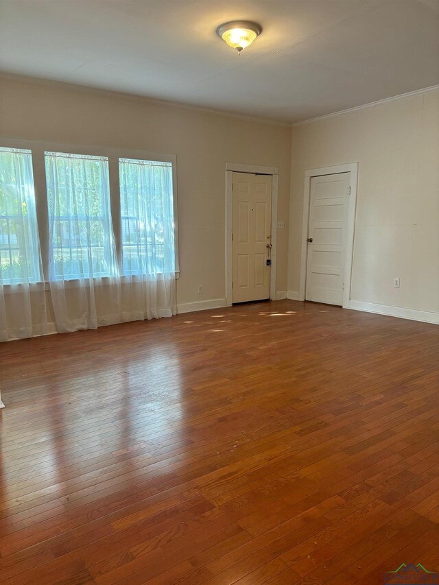 empty room featuring hardwood / wood-style floors and ornamental molding