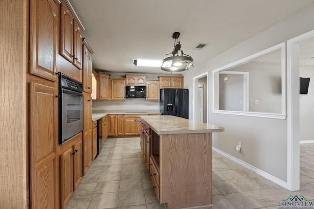 kitchen with black appliances, a center island, hanging light fixtures, and light tile patterned flooring