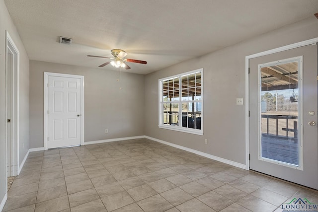 spare room with ceiling fan and light tile patterned floors