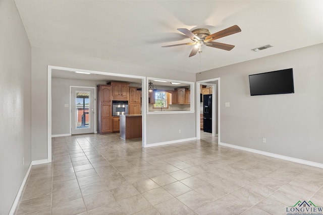 unfurnished living room featuring ceiling fan and light tile patterned floors