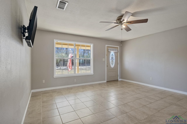 tiled foyer featuring ceiling fan and a textured ceiling