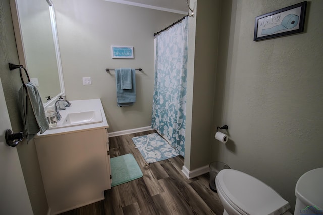 bathroom with vanity, wood finished floors, toilet, and baseboards