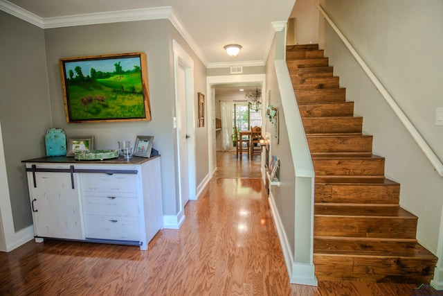 interior space featuring crown molding, visible vents, baseboards, and wood finished floors