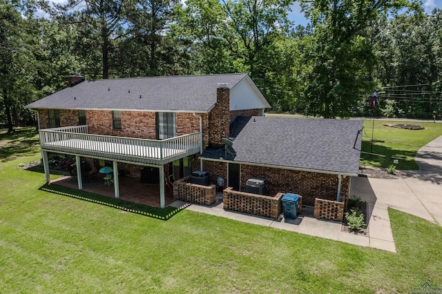 back of property featuring a yard, roof with shingles, a patio, and a chimney