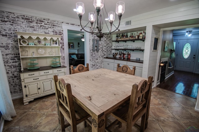 dining area with brick wall, visible vents, and crown molding