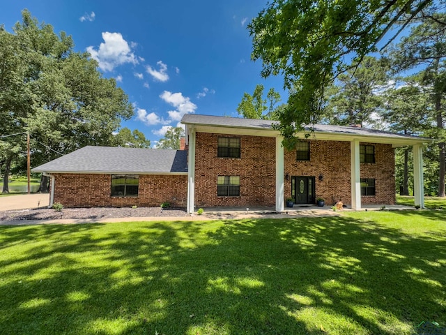 back of house featuring a yard and brick siding