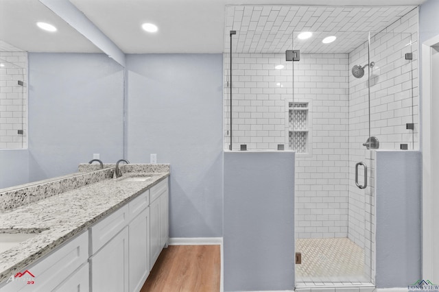 bathroom featuring vanity, a shower with shower door, and hardwood / wood-style flooring