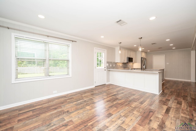 169 Hidden Frst, Longview, TX 75605 - kitchen featuring stainless steel appliances, ornamental molding, light countertops, dark wood-style floors, and a peninsula