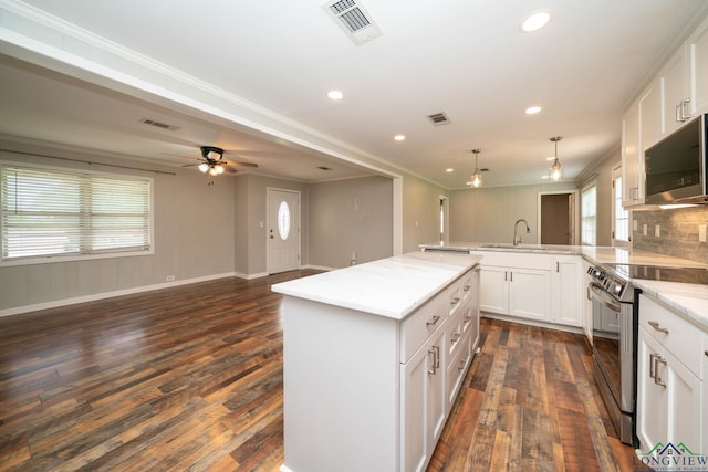 169 Hidden Frst, Longview, TX 75605 - kitchen featuring appliances with stainless steel finishes, a peninsula, open floor plan, ornamental molding, and white cabinetry