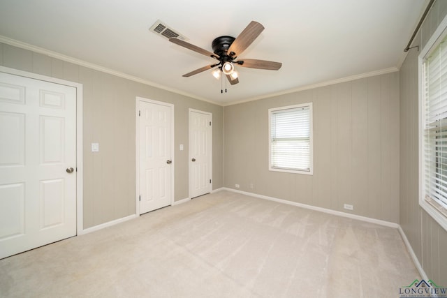 169 Hidden Frst, Longview, TX 75605 - unfurnished bedroom featuring ornamental molding, light colored carpet, baseboards, a ceiling fan, and multiple closets