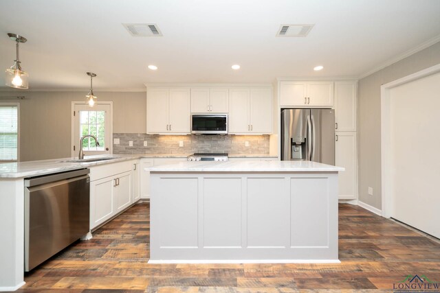 169 Hidden Frst, Longview, TX 75605 - kitchen with appliances with stainless steel finishes, a sink, ornamental molding, a center island, and tasteful backsplash
