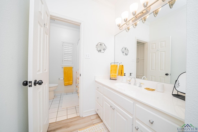 bathroom with tile patterned flooring, baseboards, a chandelier, toilet, and vanity