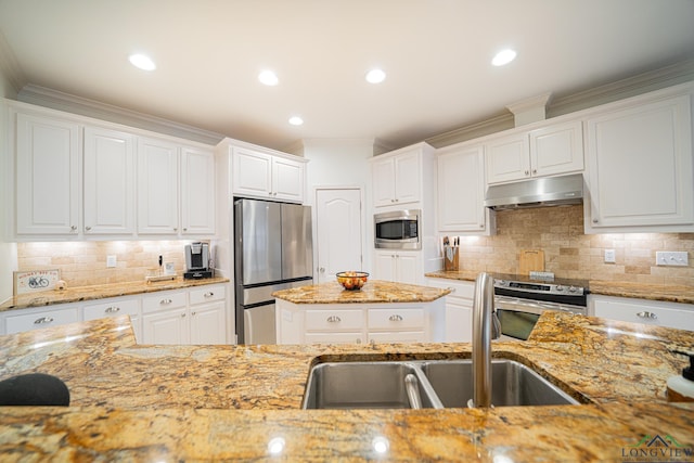 kitchen with light stone countertops, under cabinet range hood, stainless steel appliances, white cabinetry, and a sink