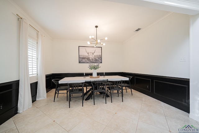 dining room featuring visible vents, an inviting chandelier, wainscoting, crown molding, and light tile patterned floors