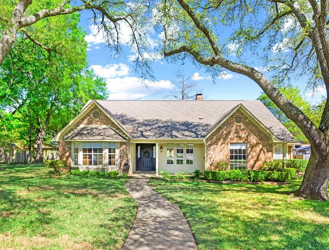 5900 Sheffield Dr, Tyler, TX 75703 - view of front of home with brick siding, a shingled roof, a front lawn, and a chimney