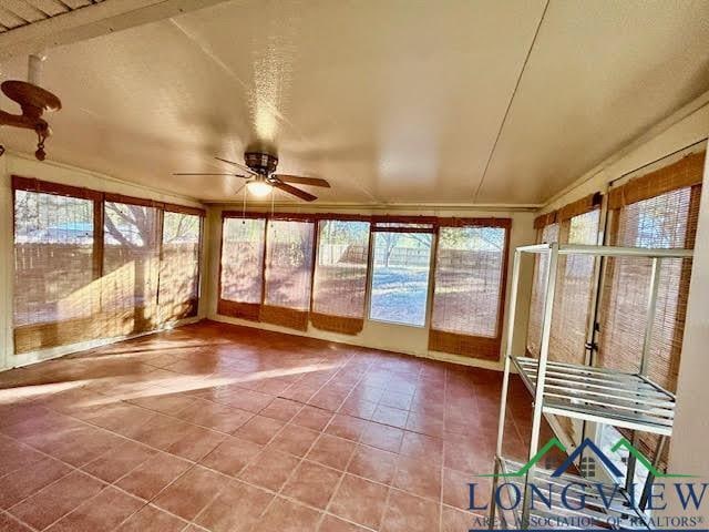 unfurnished sunroom featuring ceiling fan and lofted ceiling