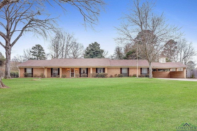 single story home featuring a garage, driveway, a chimney, a front lawn, and brick siding