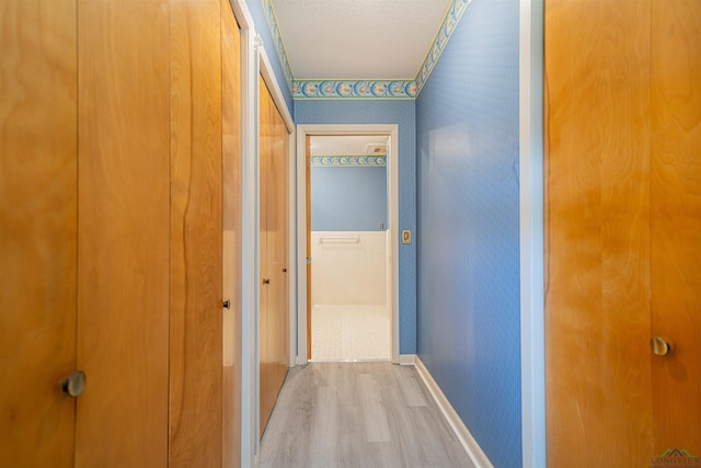 201 Bronco Ln, Linden, TX 75563 - corridor featuring wallpapered walls, light wood-type flooring, and a textured ceiling