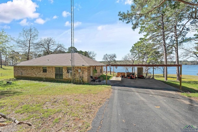 2574 County Road 3412, Chandler, TX 75758 - view of front of property featuring driveway, a front yard, brick siding, and a water view