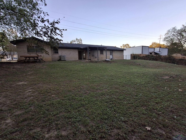 rear view of house featuring a yard