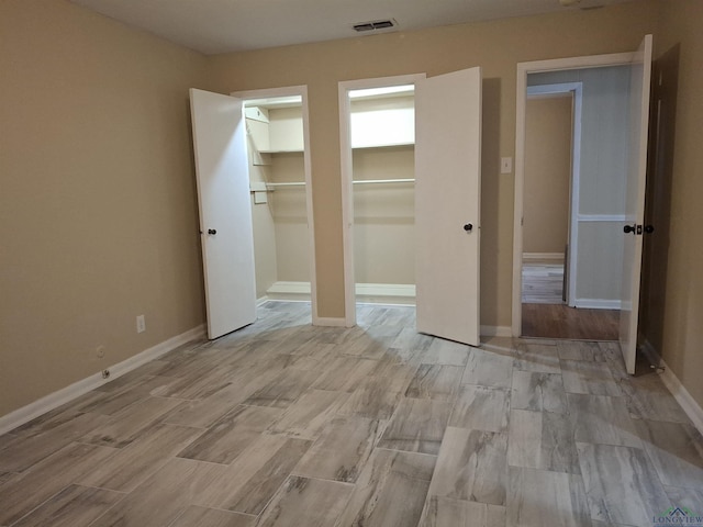 unfurnished bedroom with a walk in closet