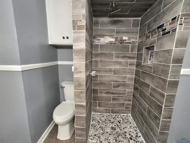 bathroom with toilet and tiled shower