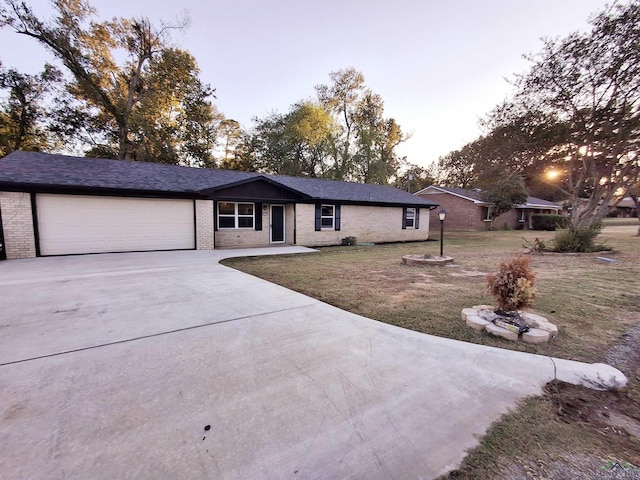 single story home with a garage and a front lawn