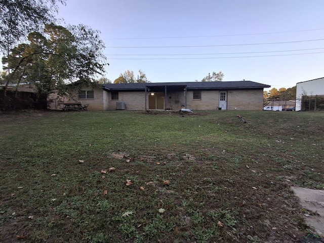 back of house with a lawn and cooling unit