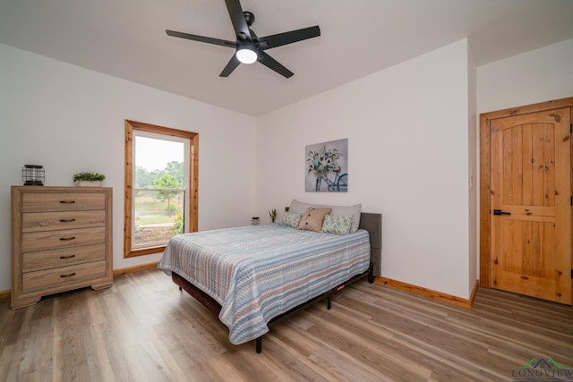 bedroom with hardwood / wood-style flooring, access to exterior, and ceiling fan