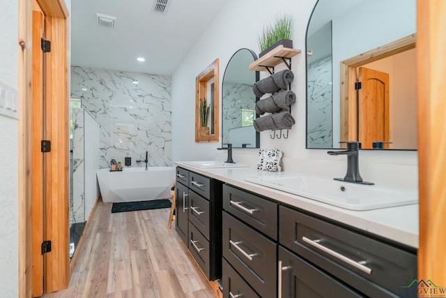 bathroom featuring a bathing tub, wood-type flooring, and vanity