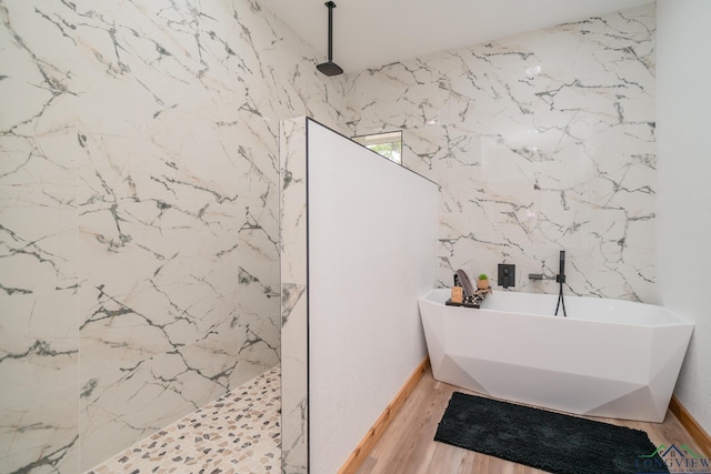 bathroom featuring plus walk in shower and wood-type flooring