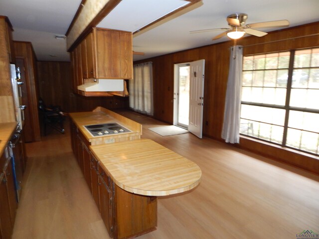 2231 W Stae Highway 154, Gilmer, TX 75644 - kitchen featuring light countertops, light wood-type flooring, white electric cooktop, and wood walls