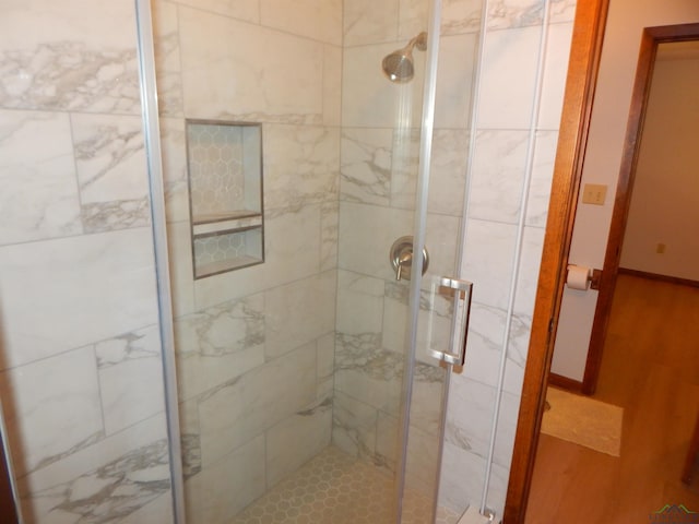 2231 W Stae Highway 154, Gilmer, TX 75644 - bathroom featuring a shower stall, baseboards, and wood finished floors