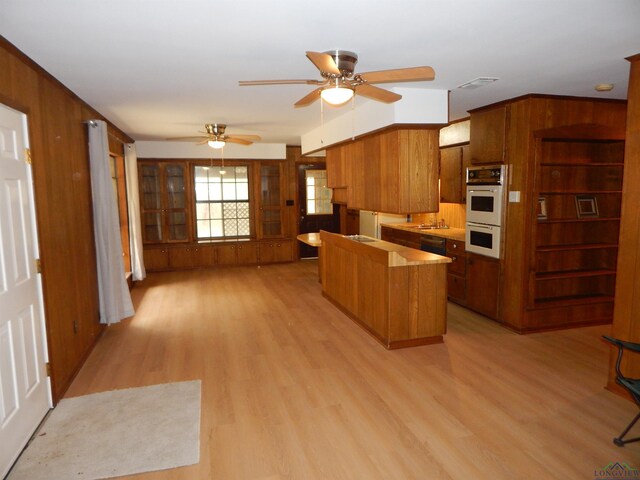 2231 W Stae Highway 154, Gilmer, TX 75644 - kitchen featuring light wood-type flooring, visible vents, brown cabinetry, and white double oven