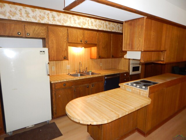 2231 W Stae Highway 154, Gilmer, TX 75644 - kitchen with white appliances, brown cabinetry, light wood-type flooring, and a sink