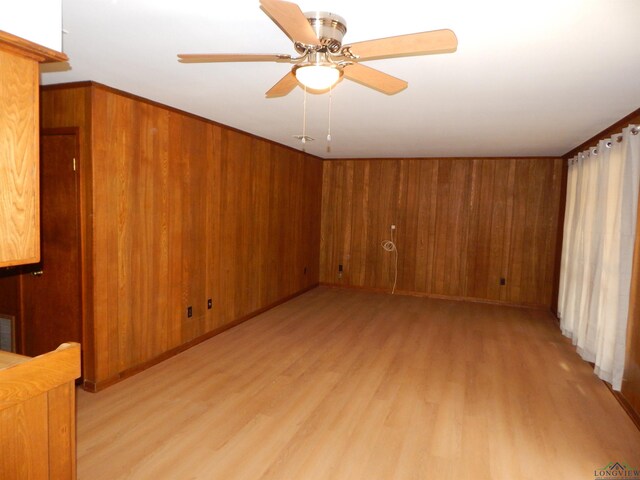 2231 W Stae Highway 154, Gilmer, TX 75644 - unfurnished room featuring wood walls, light wood finished floors, and a ceiling fan