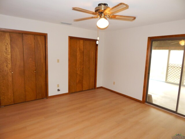 2231 W Stae Highway 154, Gilmer, TX 75644 - unfurnished bedroom with light wood-type flooring, visible vents, baseboards, and two closets