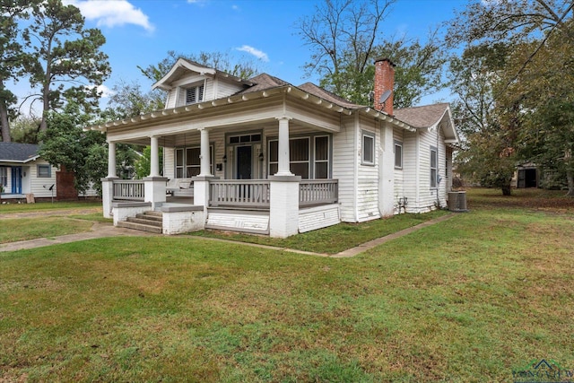 bungalow-style home featuring a porch, central AC unit, and a front yard