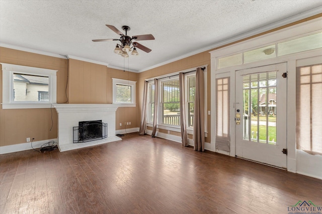 unfurnished living room with crown molding, plenty of natural light, and dark hardwood / wood-style flooring