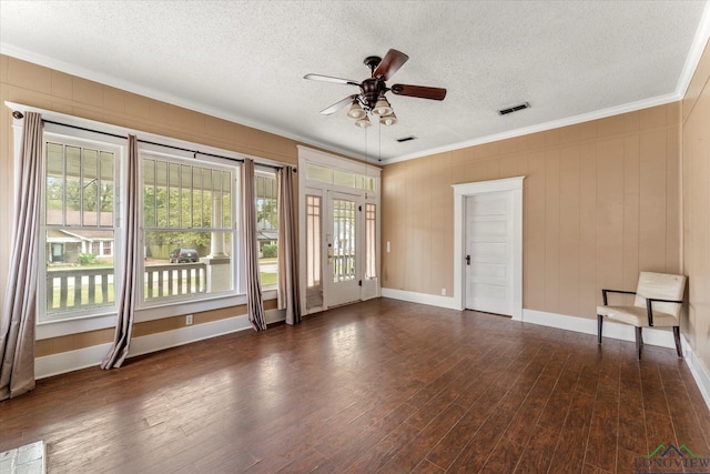 empty room with dark wood-type flooring, ceiling fan, crown molding, and a textured ceiling