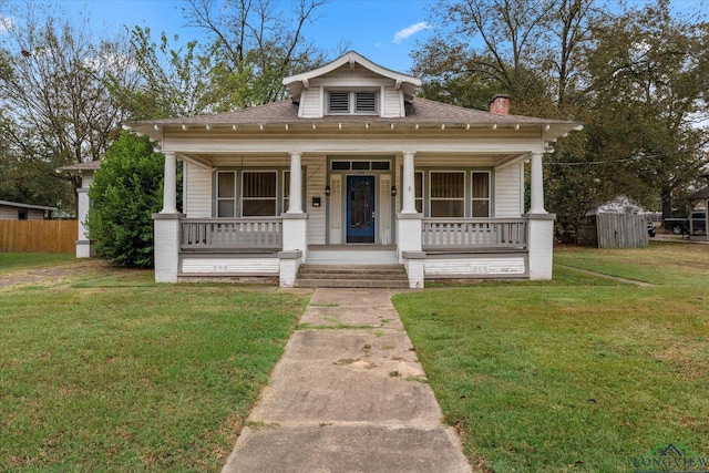 bungalow-style house featuring covered porch and a front lawn