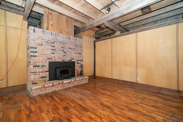 basement with a wood stove, dark wood-type flooring, and wooden ceiling