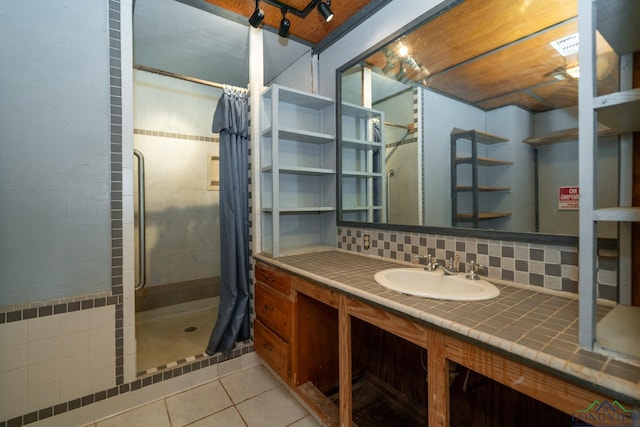 bathroom featuring vanity, tasteful backsplash, tile patterned floors, and walk in shower