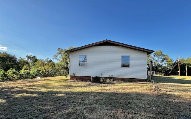 view of property exterior featuring a yard and central AC