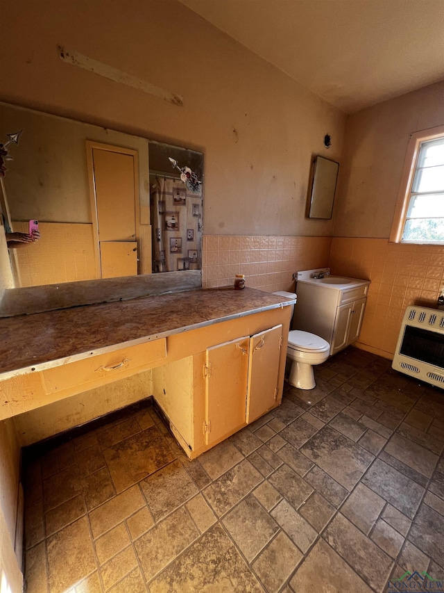 bathroom with heating unit, tile walls, and toilet