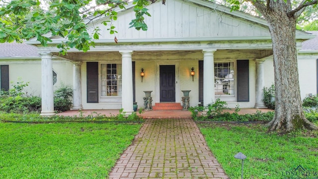 2003 Broadway Blvd, Kilgore, TX 75662 - neoclassical home with a porch, board and batten siding, a front yard, and brick siding