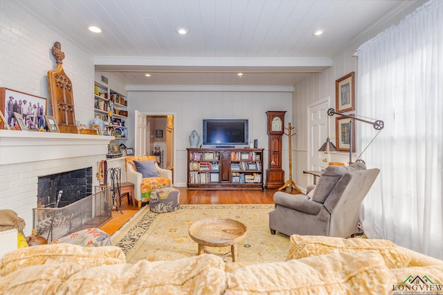 2003 Broadway Blvd, Kilgore, TX 75662 - living area featuring wood finished floors, a brick fireplace, a wooden ceiling with exposed beams, recessed lighting, and ornamental molding