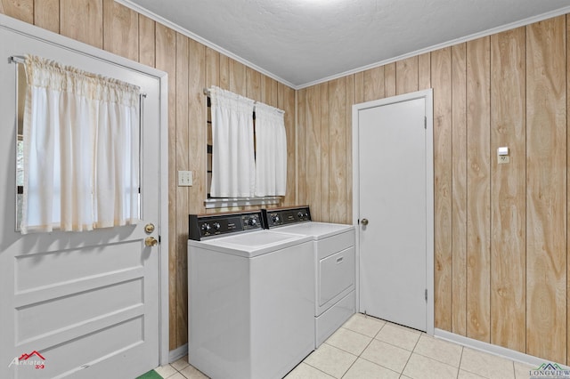 laundry room with light tile patterned floors, wooden walls, laundry area, independent washer and dryer, and crown molding